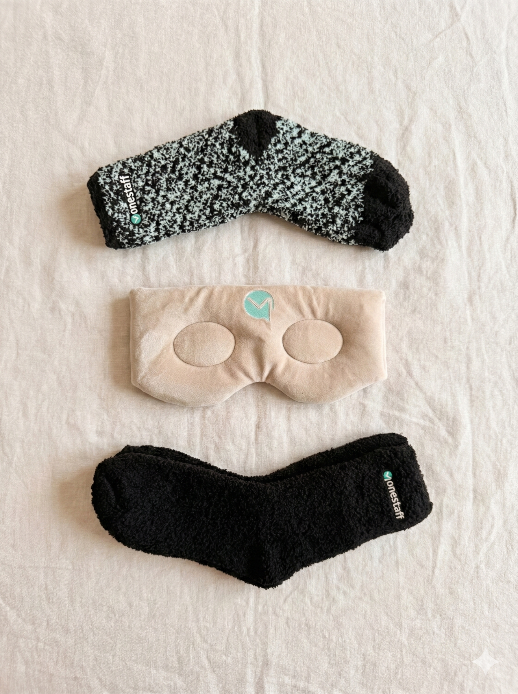 OneStaff Cozy Kit flat lay — fuzzy socks and branded eye mask