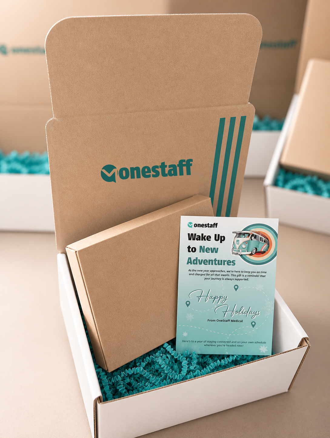 OneStaff-branded holiday gift box opened to reveal a Wake Up to New Adventures Happy Holidays card