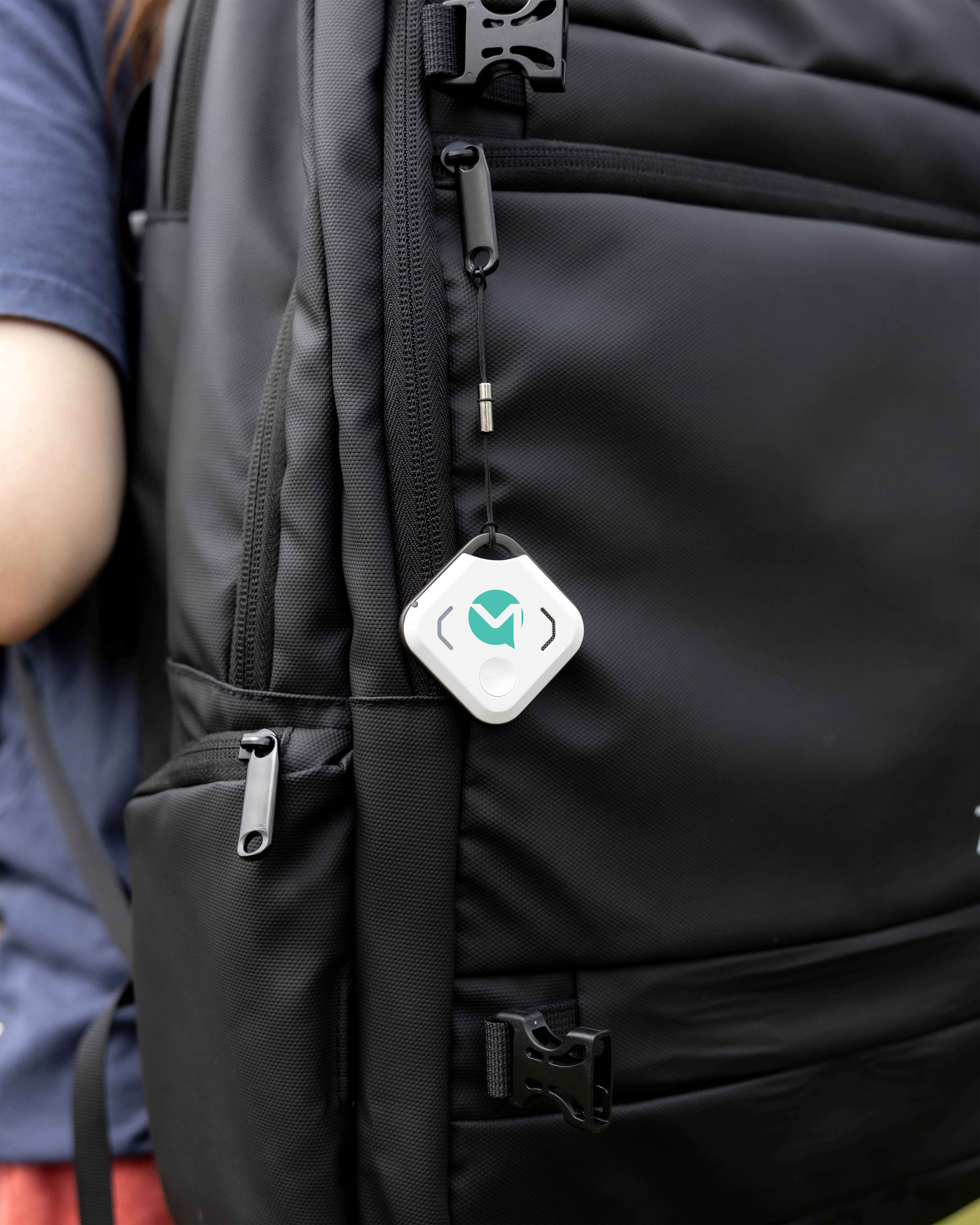 OneStaff tracker clipped to the front of a black backpack