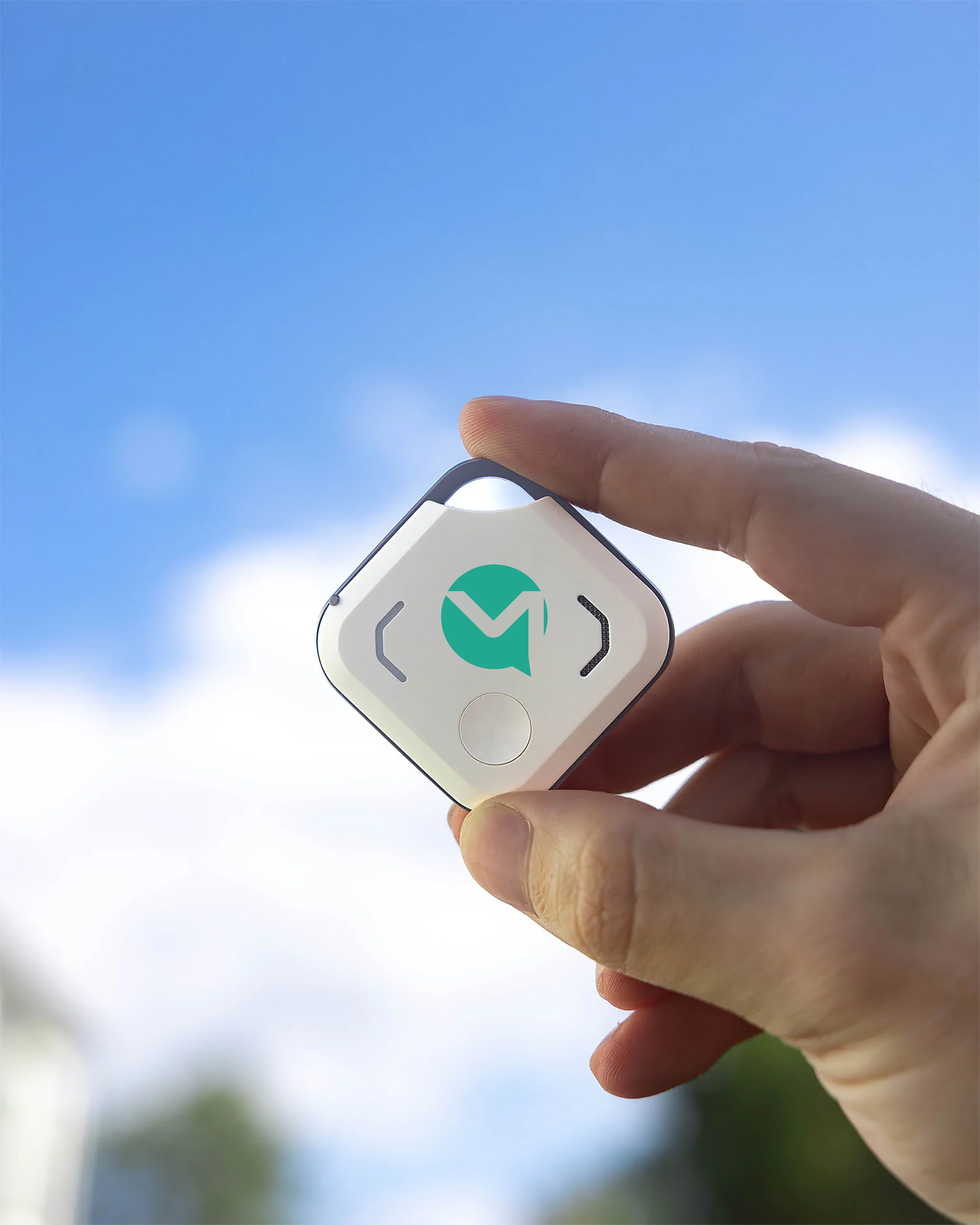 OneStaff Bluetooth tracker held against a clear blue sky